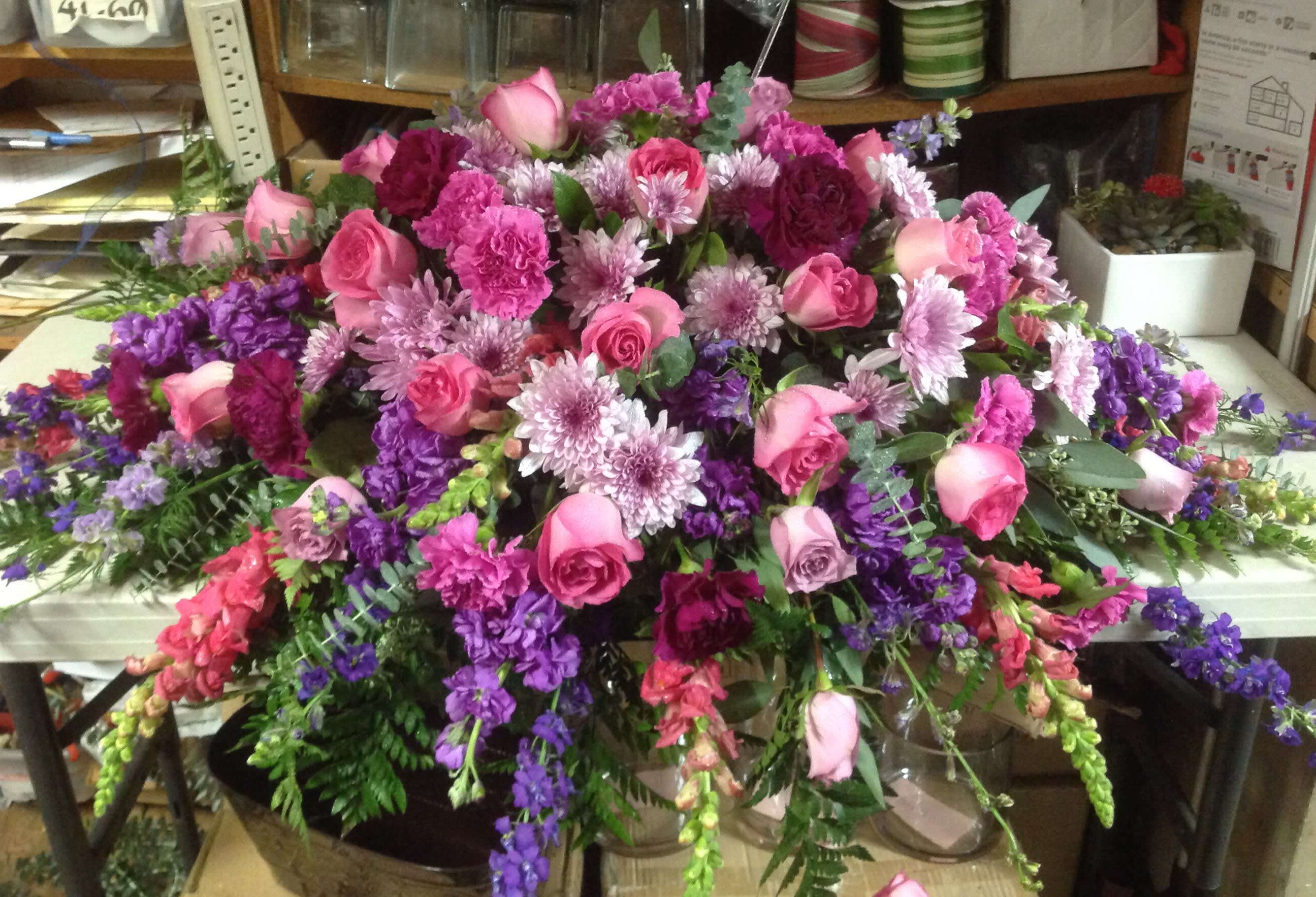 Large arrangement of pink roses and purple flowers on a table