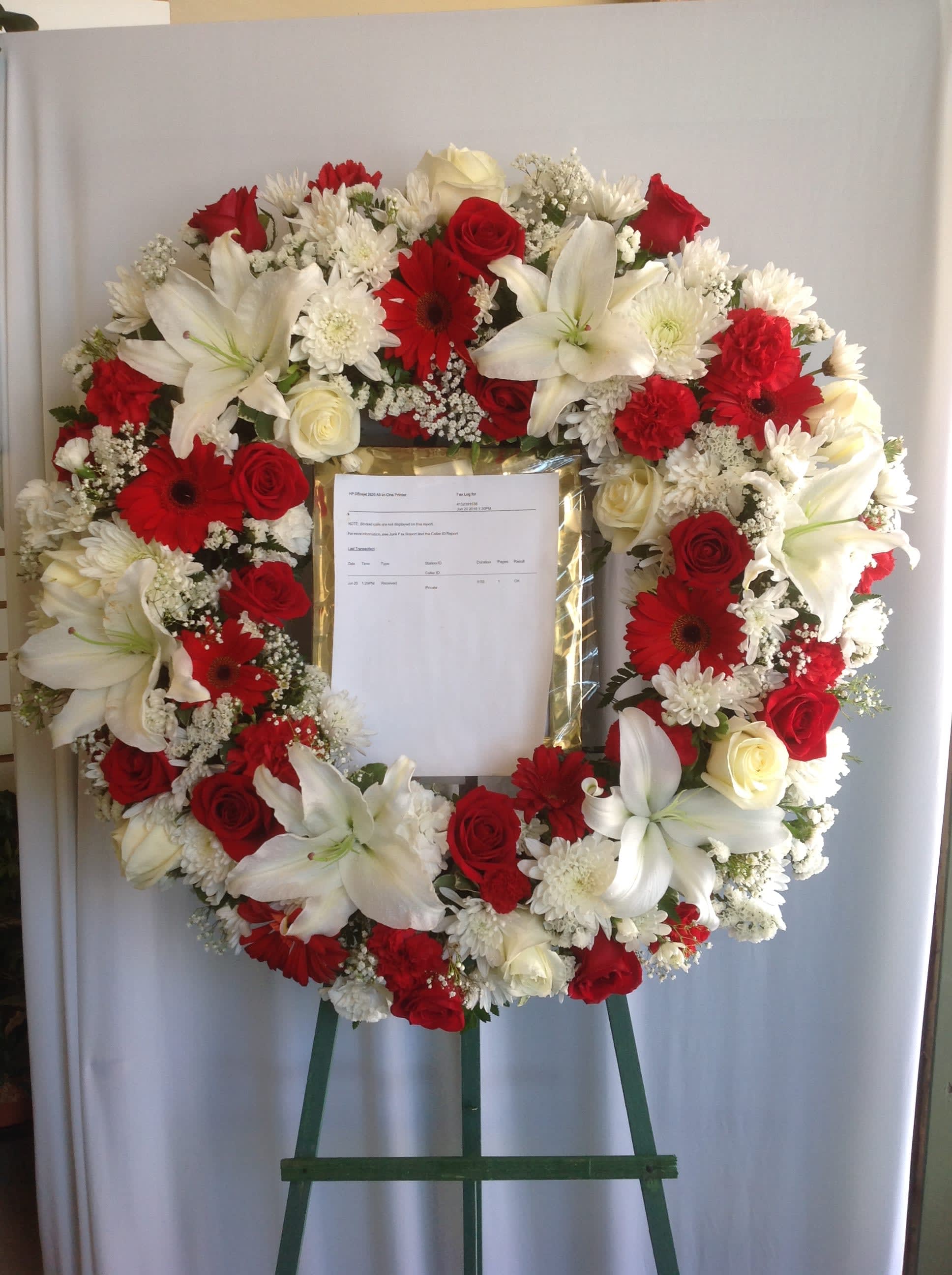 Heart-shaped wreath of red and white flowers on an easel