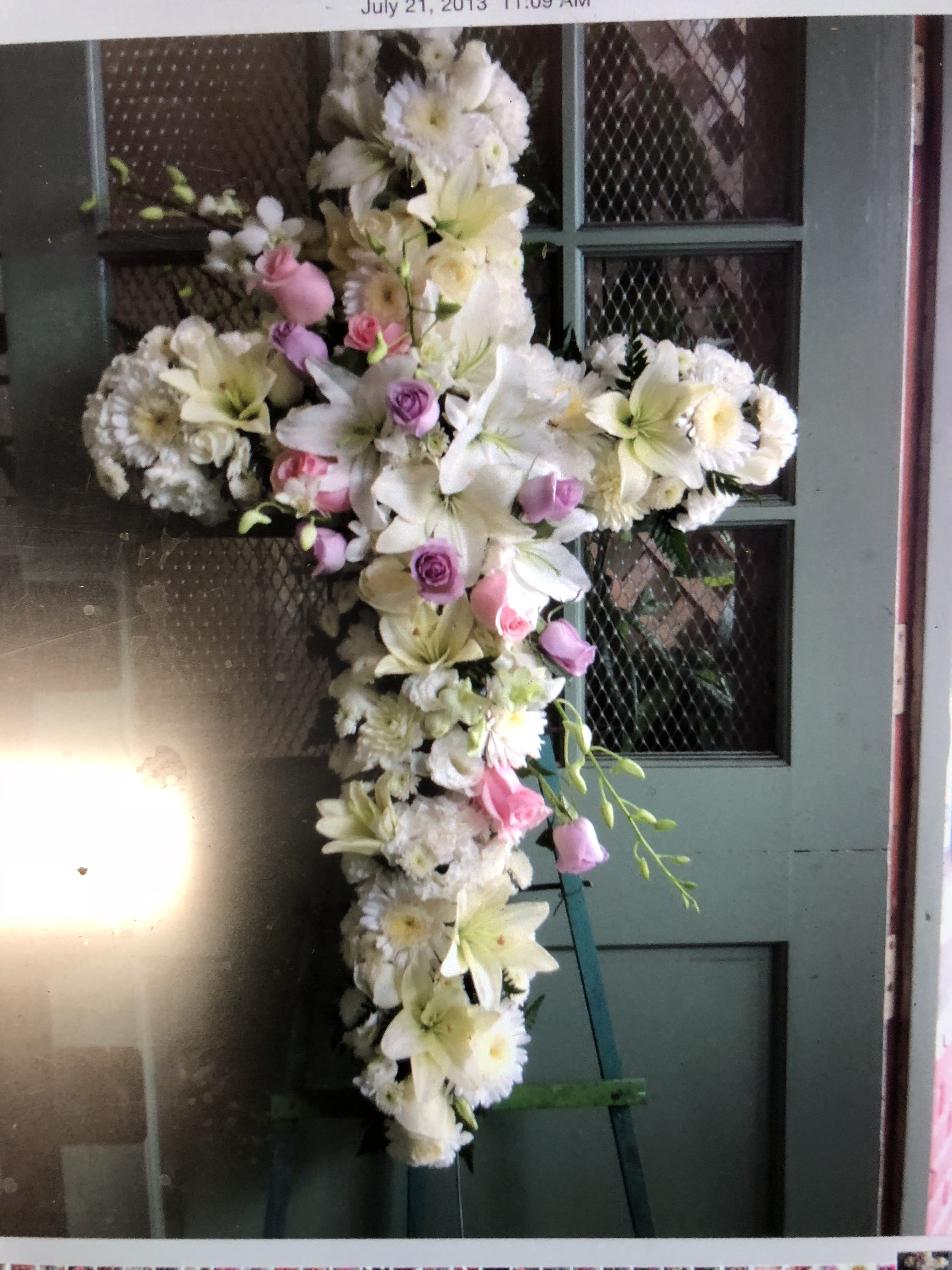 Cross-shaped floral spray with white lilies, daisies, and pink roses