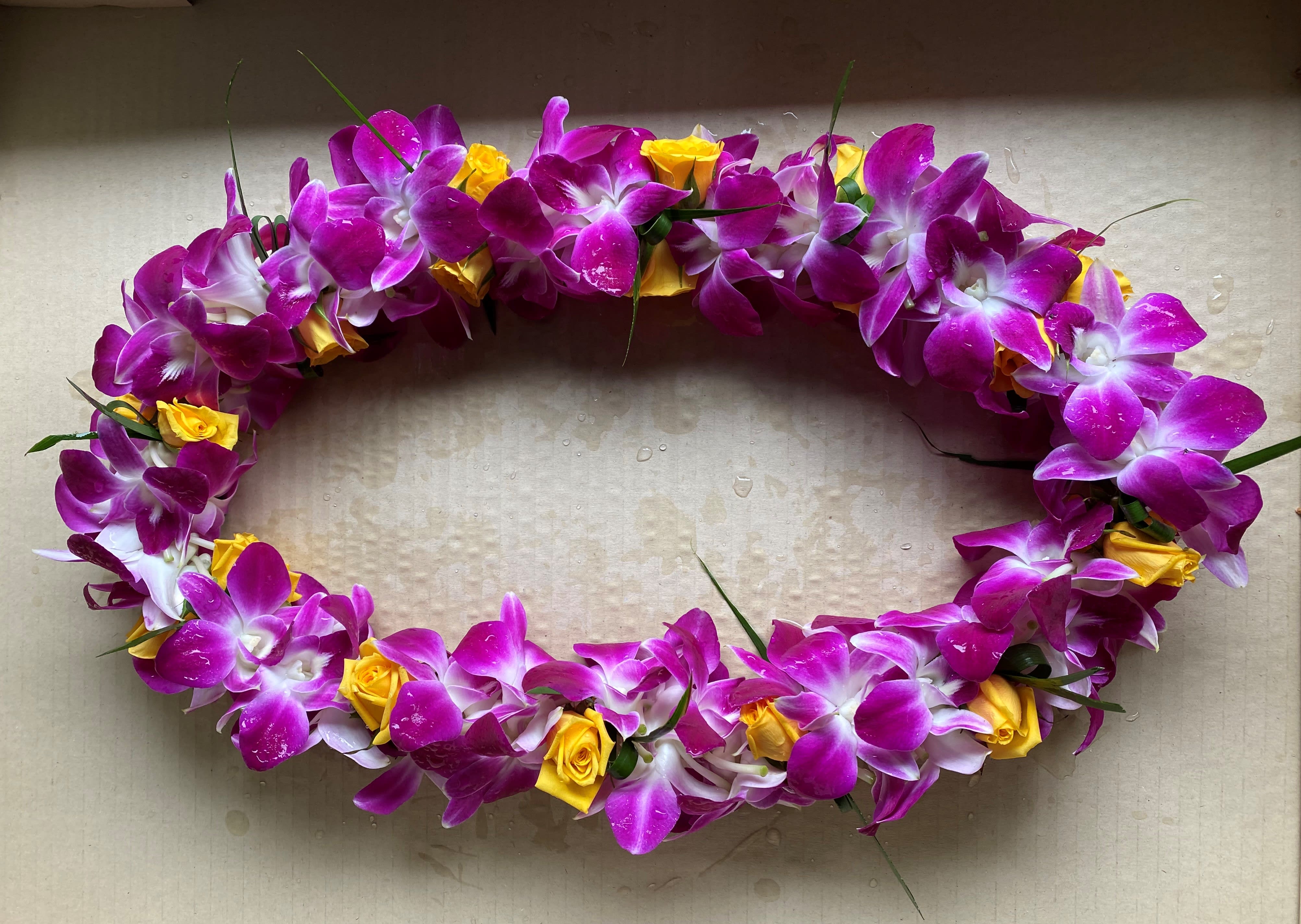 Oval floral lei with purple orchids and yellow roses
