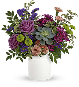 Mixed bouquet in a white vase with purple, pink, and green blooms