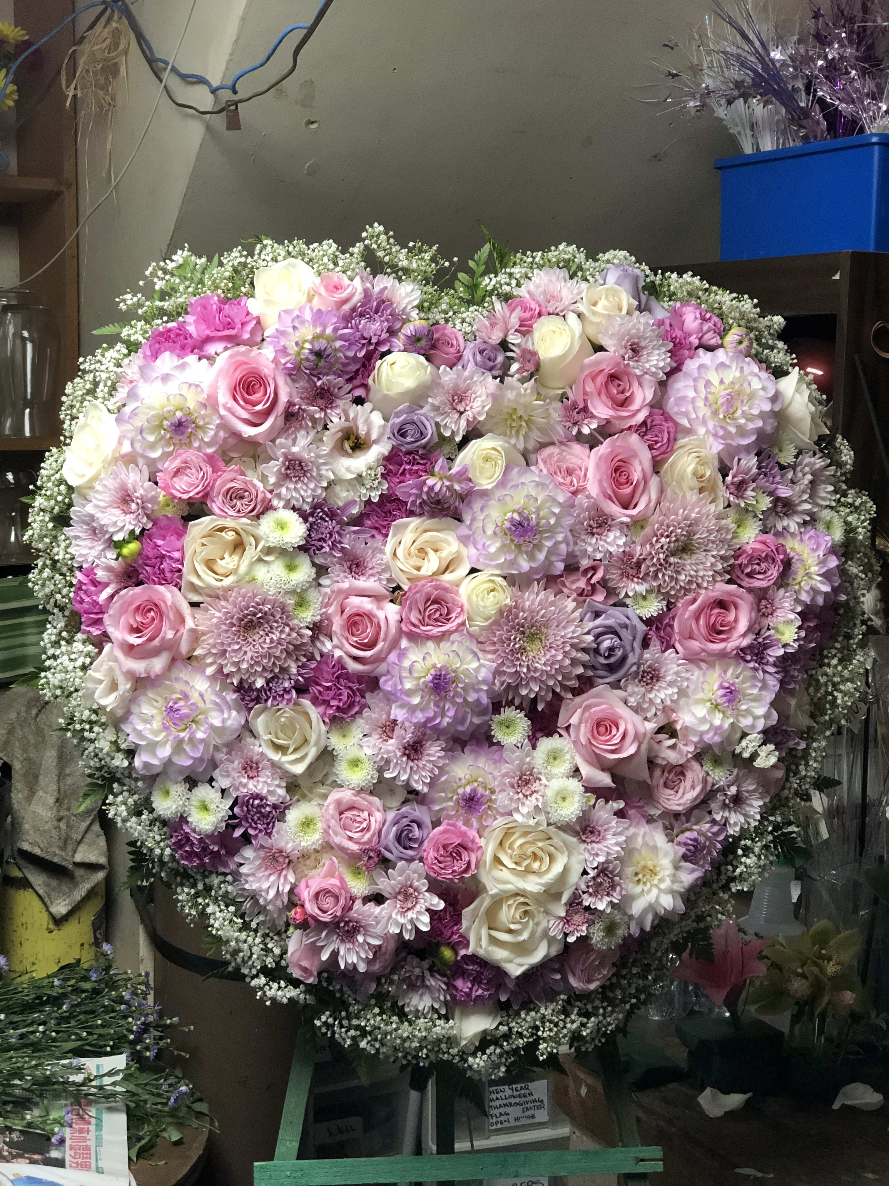 Large heart-shaped floral arrangement with pink, white, and lavender blooms