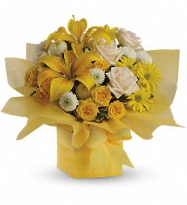 Yellow and white bouquet with lilies, roses, and daisies arranged in a yellow-wrapped square box.