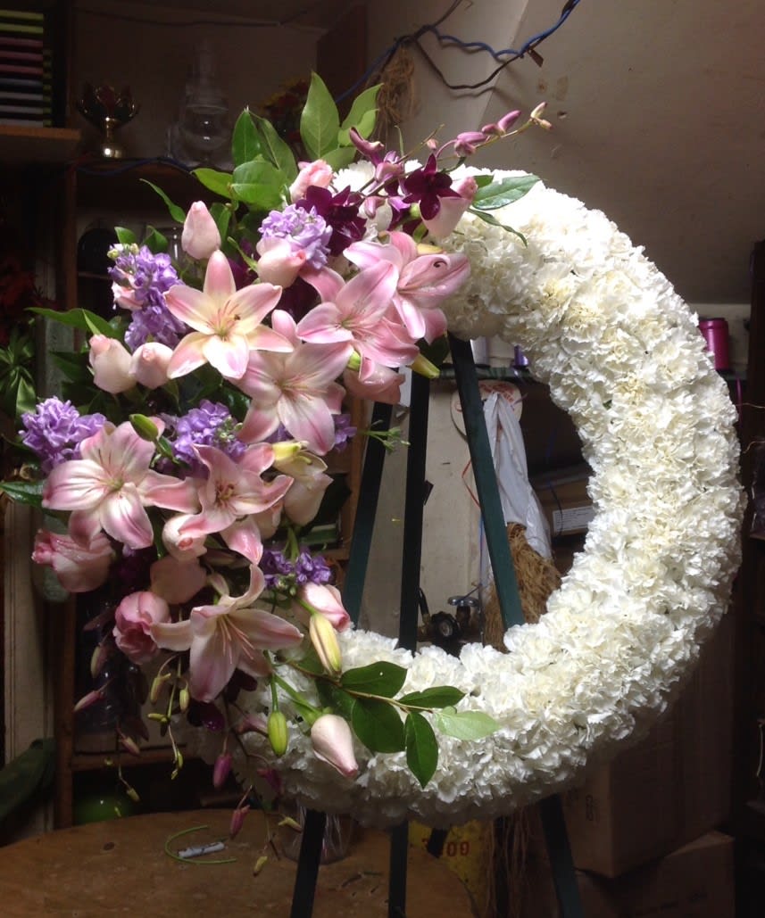 Large crescent floral wreath with pink lilies and white blooms