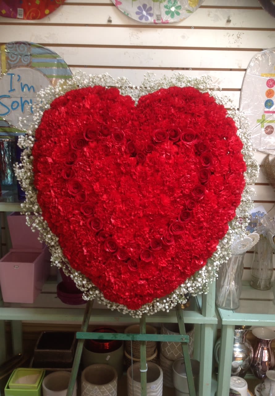 Large heart-shaped red flower arrangement on an easel