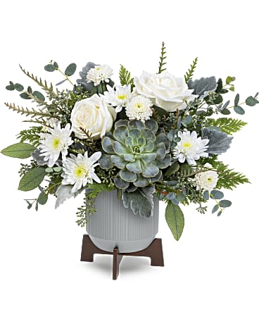 White roses and daisies arranged in a gray pot with a succulent centerpiece
