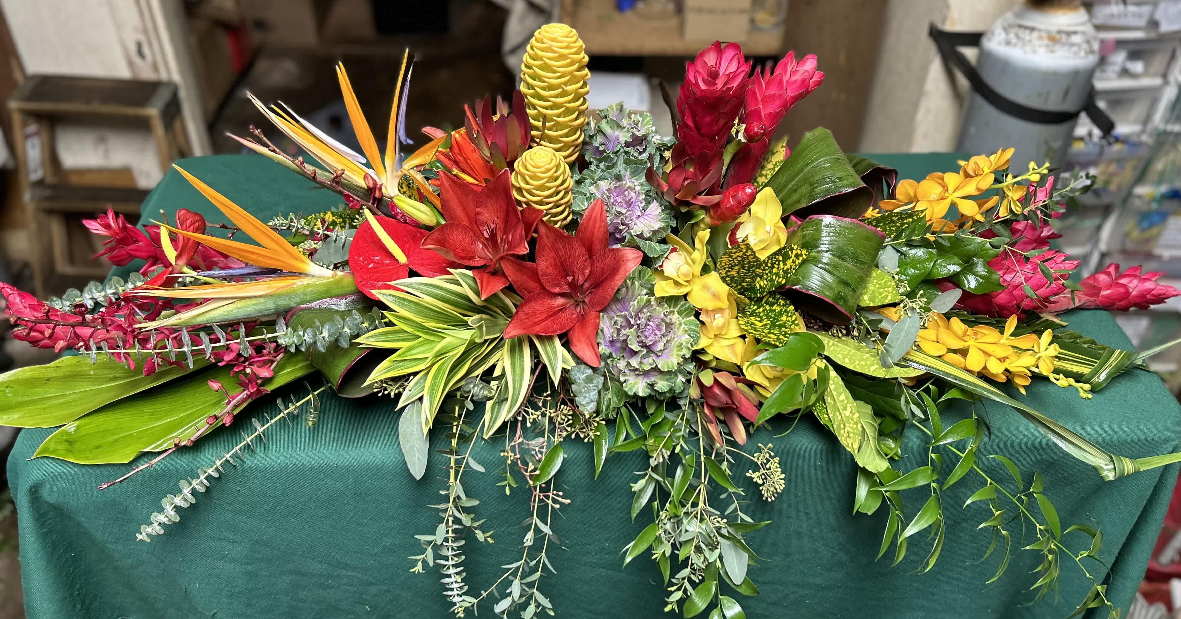 Large tropical floral arrangement with red, yellow, and pink blooms