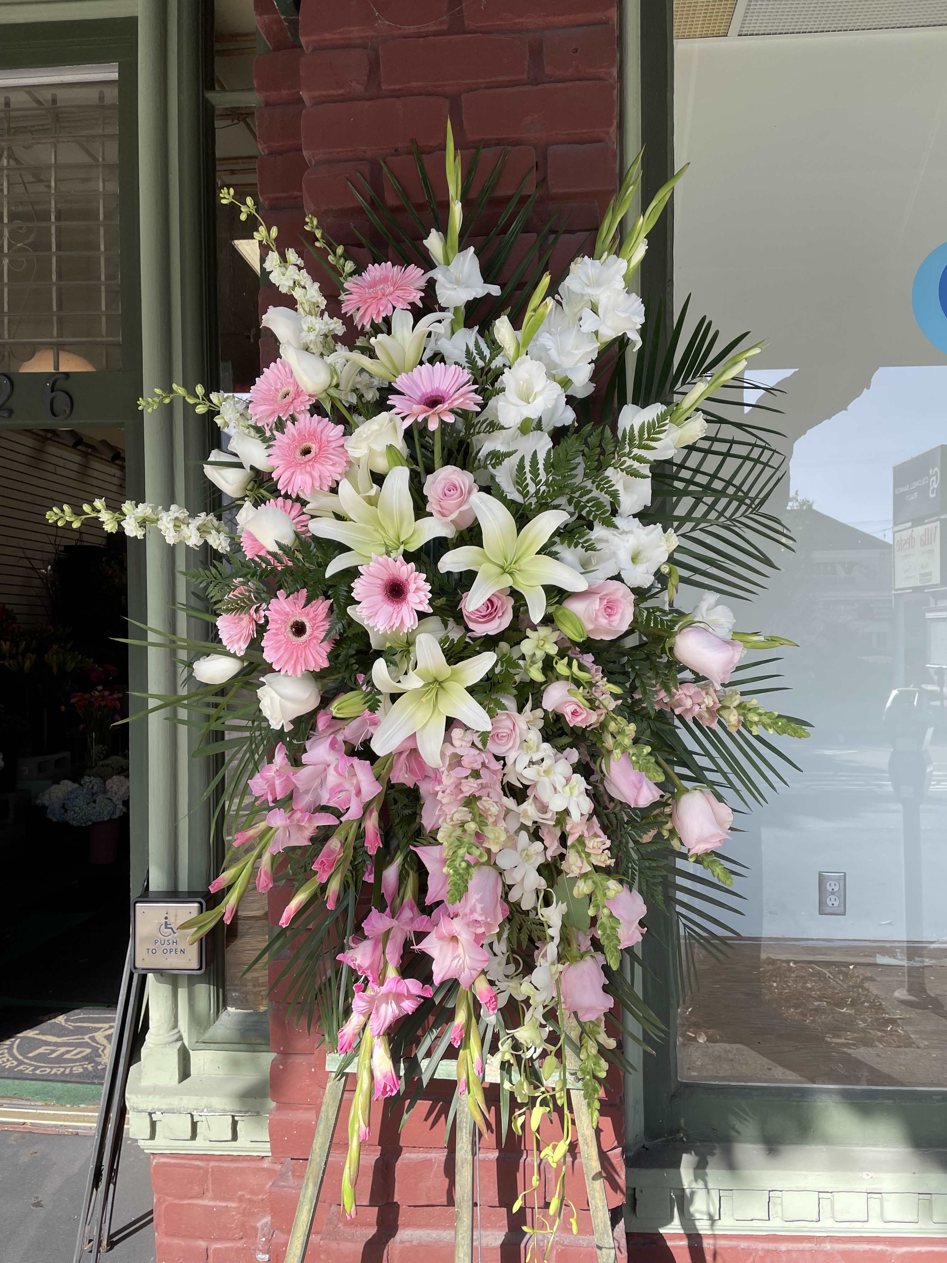 Large standing spray of pink and white flowers on an easel
