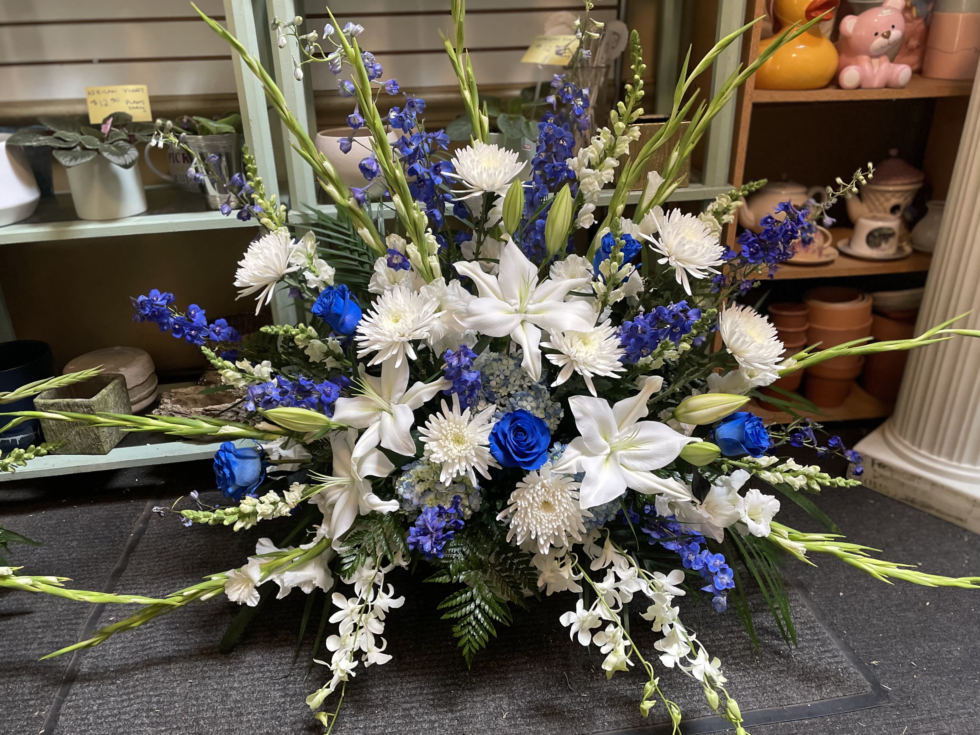 Blue and white floral arrangement with lilies and roses
