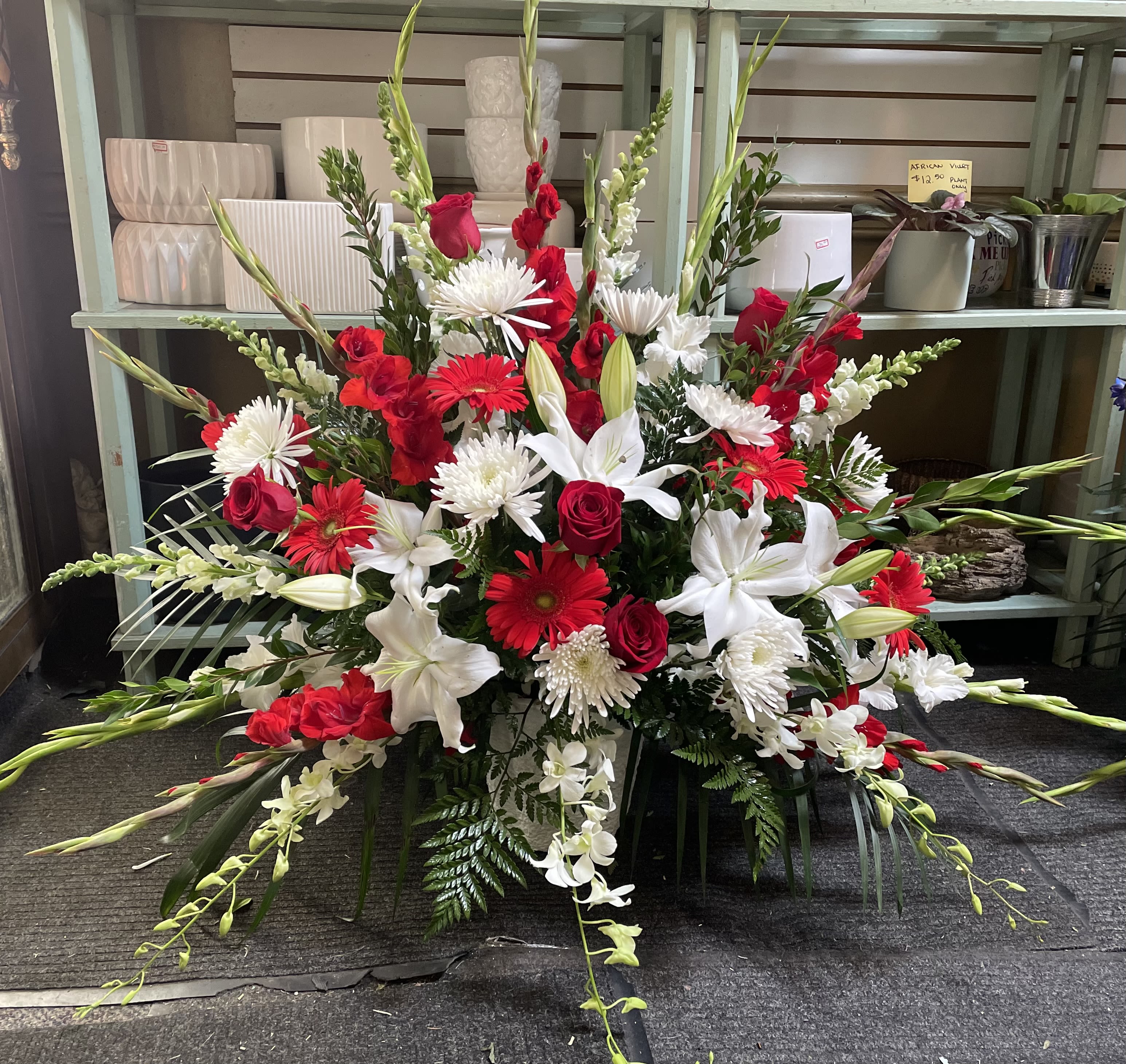 Large red and white floral spray with lilies, roses, and daisies