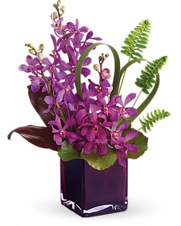 Purple orchid arrangement in a square glass vase