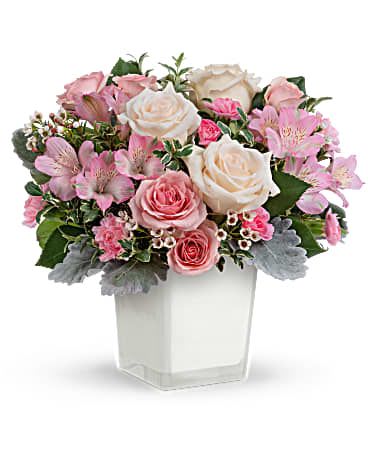 Pink and white rose bouquet in a clear square vase