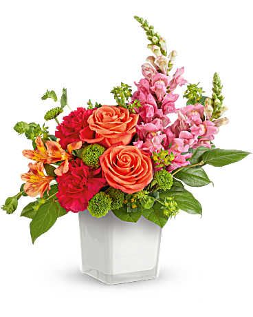 Mixed bouquet of roses, alstroemeria, and snapdragons in a white vase
