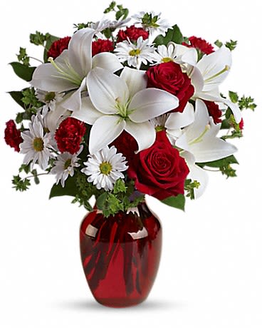 Red roses and white lilies in a red glass vase