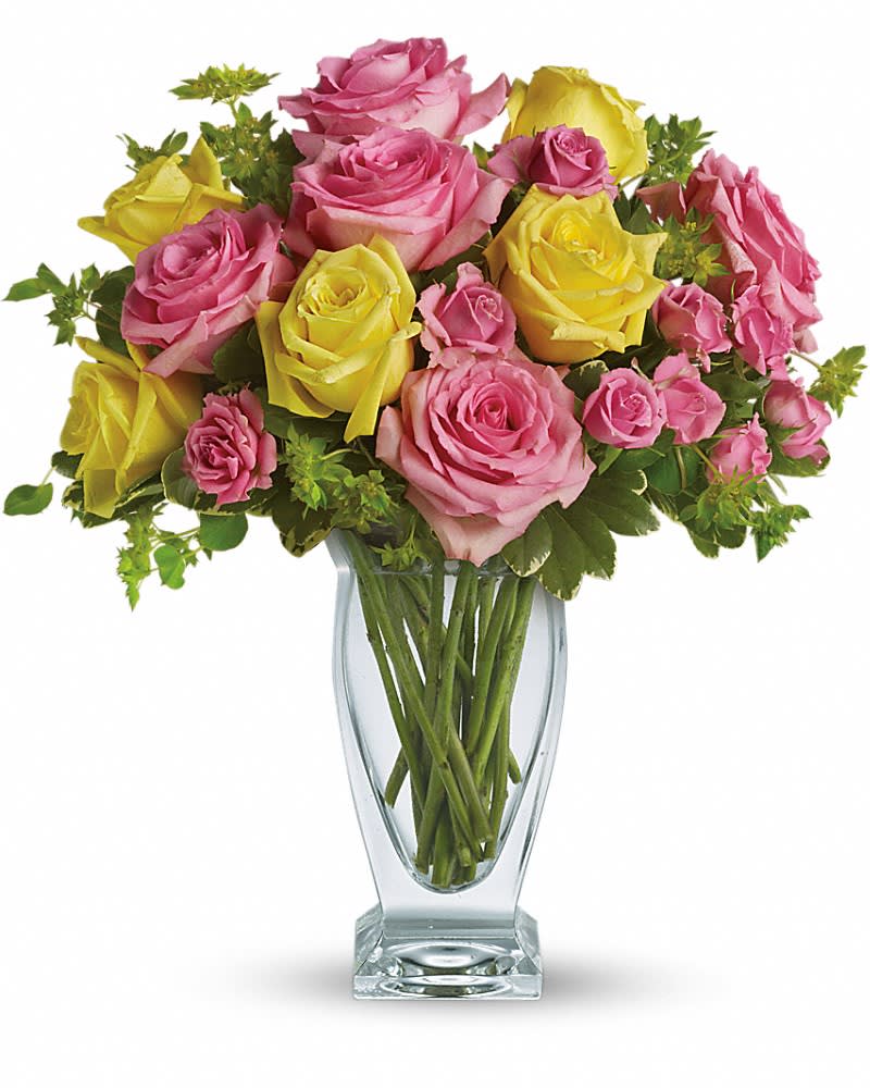Pink and yellow roses arranged in a clear glass vase
