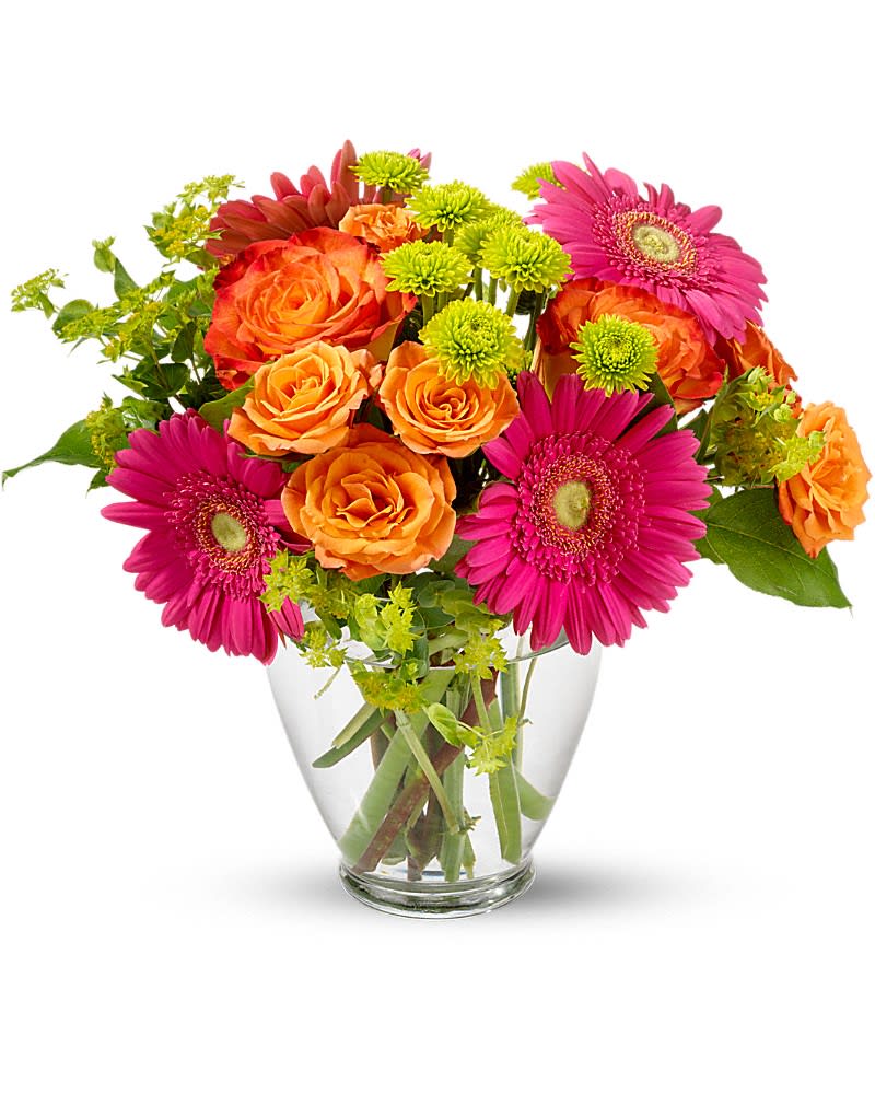 Bright bouquet of hot pink gerbera daisies, orange roses, and green mums in a clear glass vase