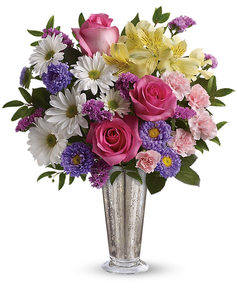 Mixed bouquet of pink roses, daisies, and purple flowers in a glass vase