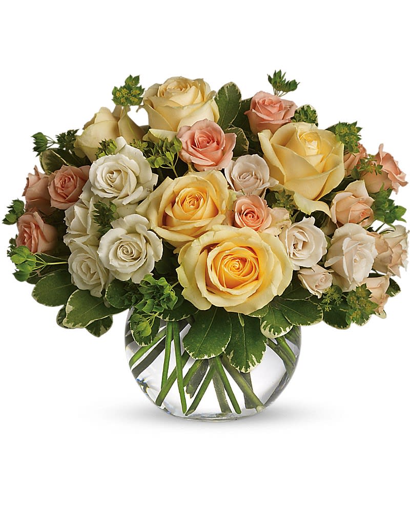 Bouquet of cream, peach, and yellow roses in a clear glass vase
