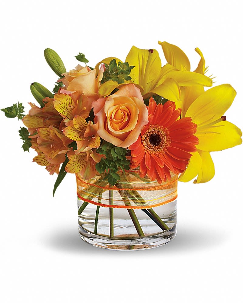 Orange roses and yellow lilies in a glass vase with an orange ribbon