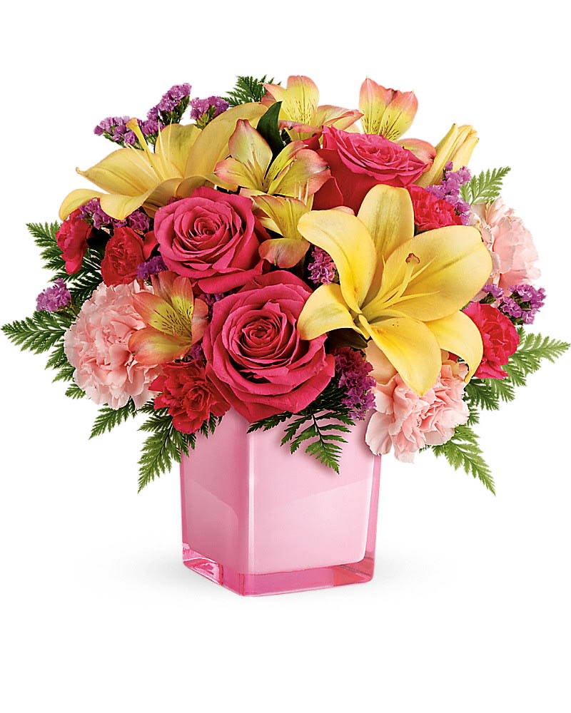 Pink roses and yellow lilies arranged in a pink vase