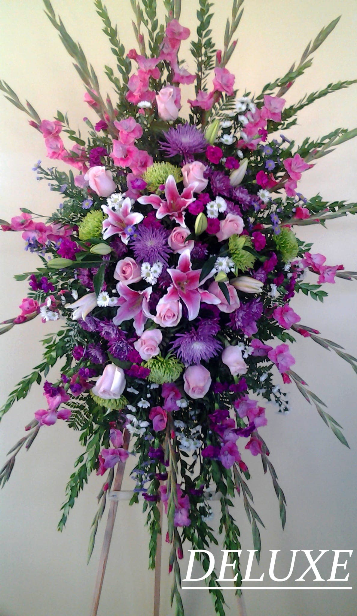 Large standing spray of pink and purple flowers on an easel