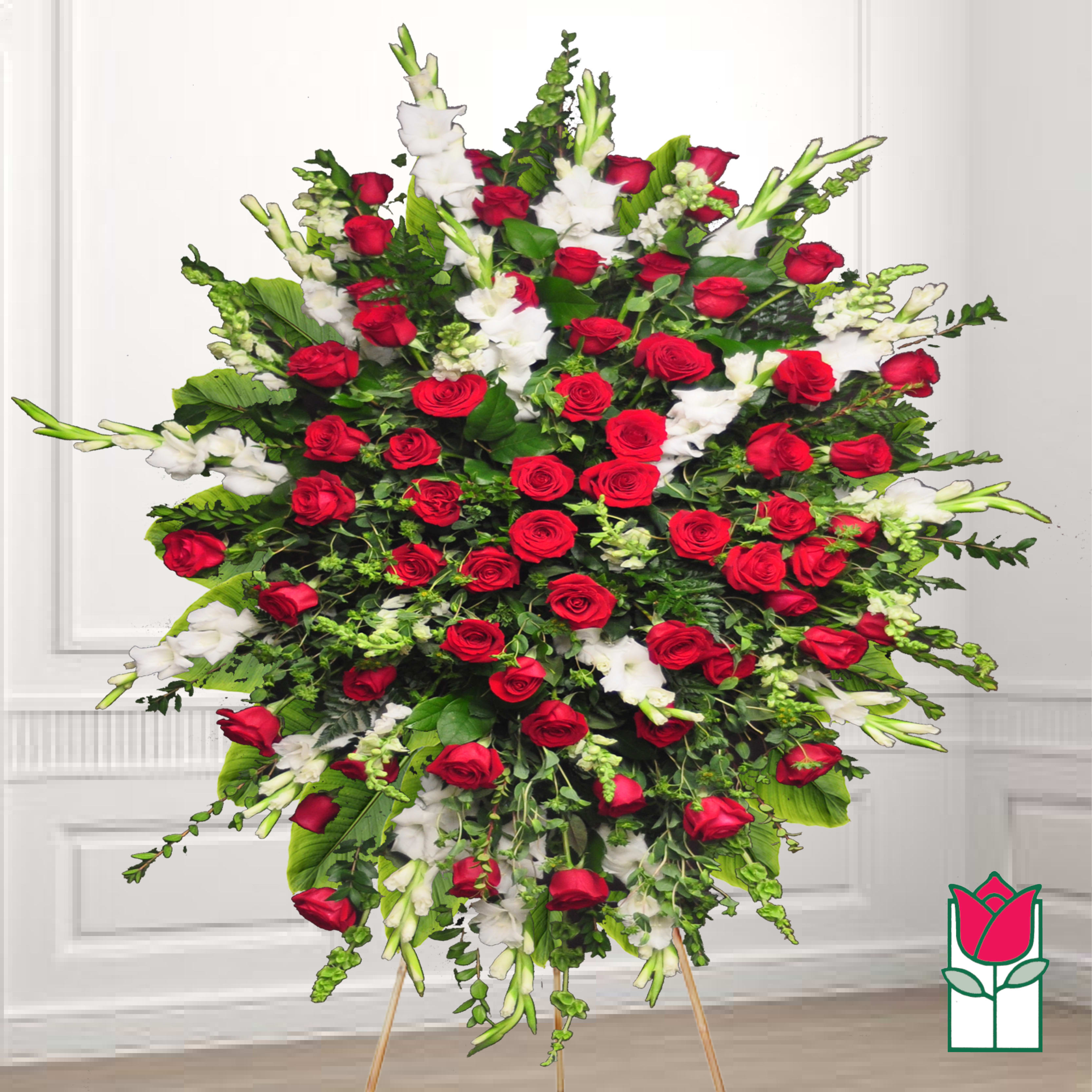 Large standing spray of red roses and white flowers on an easel