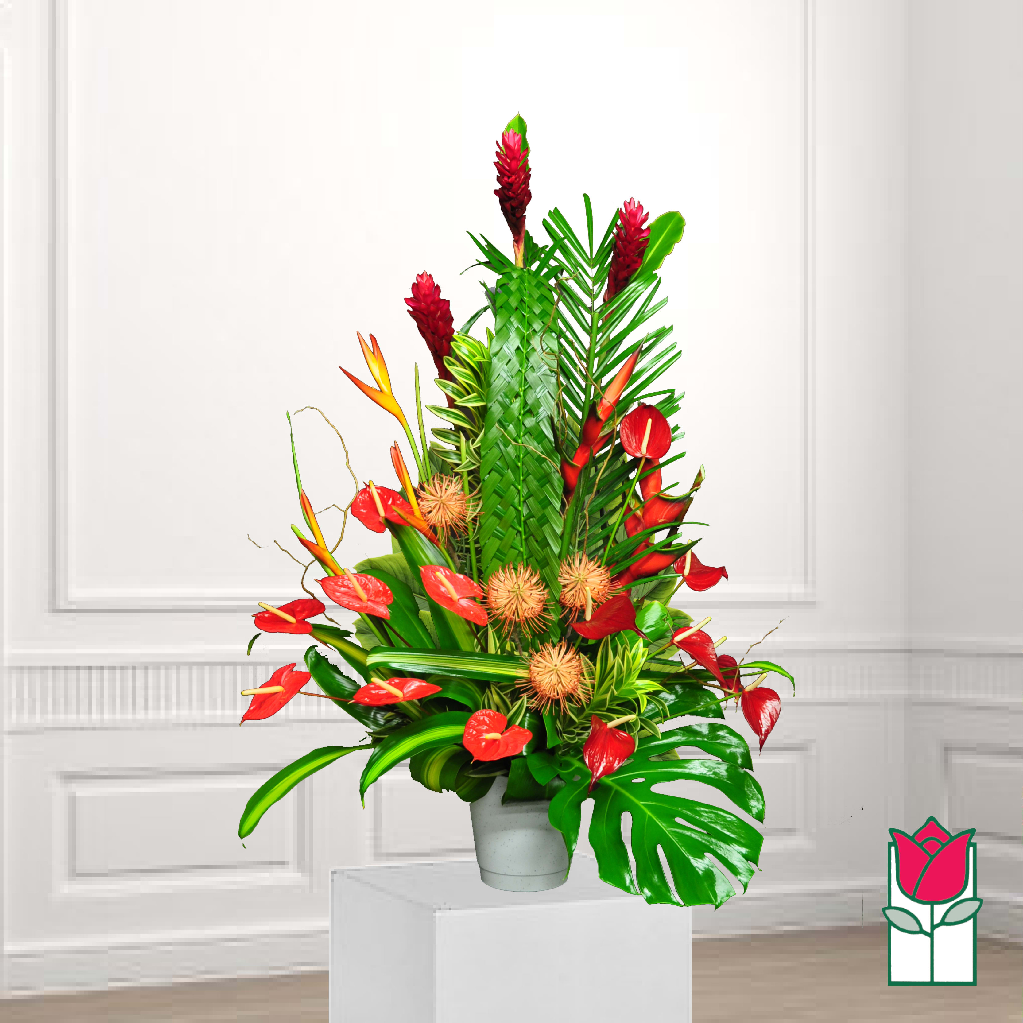 Tropical floral arrangement with red blooms in a white pot