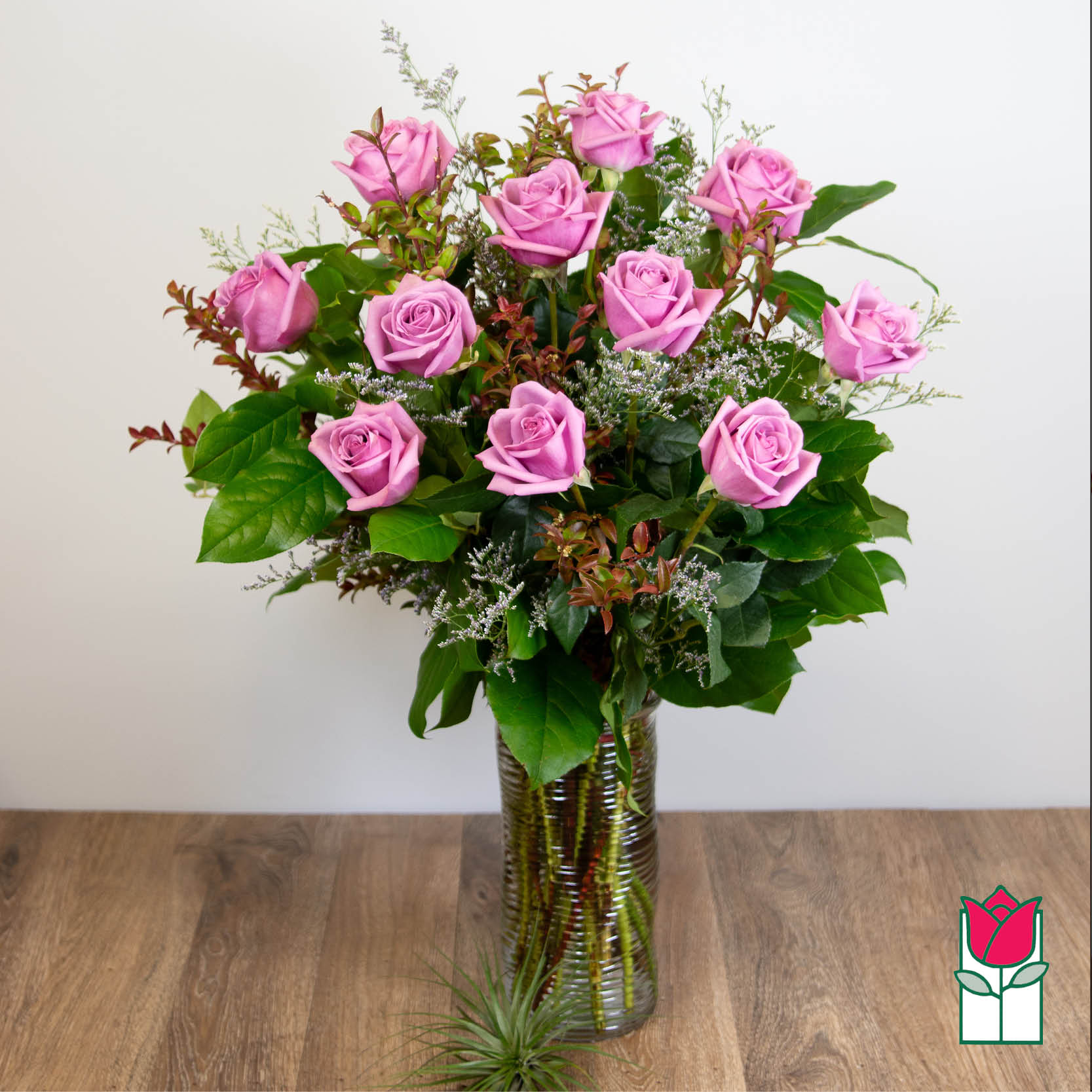 Pink roses arranged in a tall glass vase