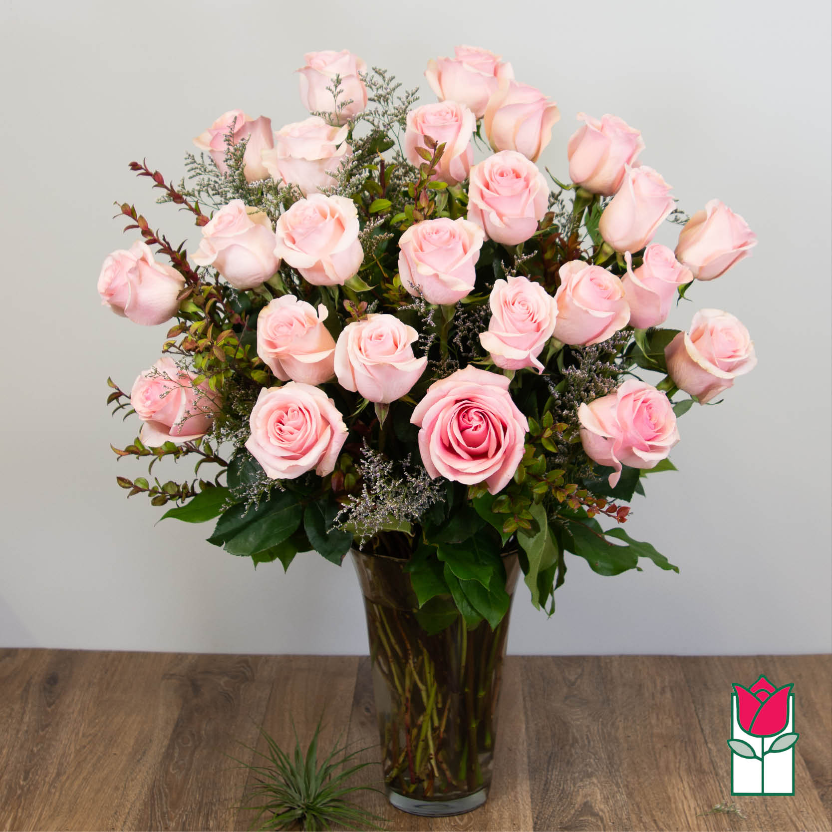 Pink roses arranged in a tall glass vase