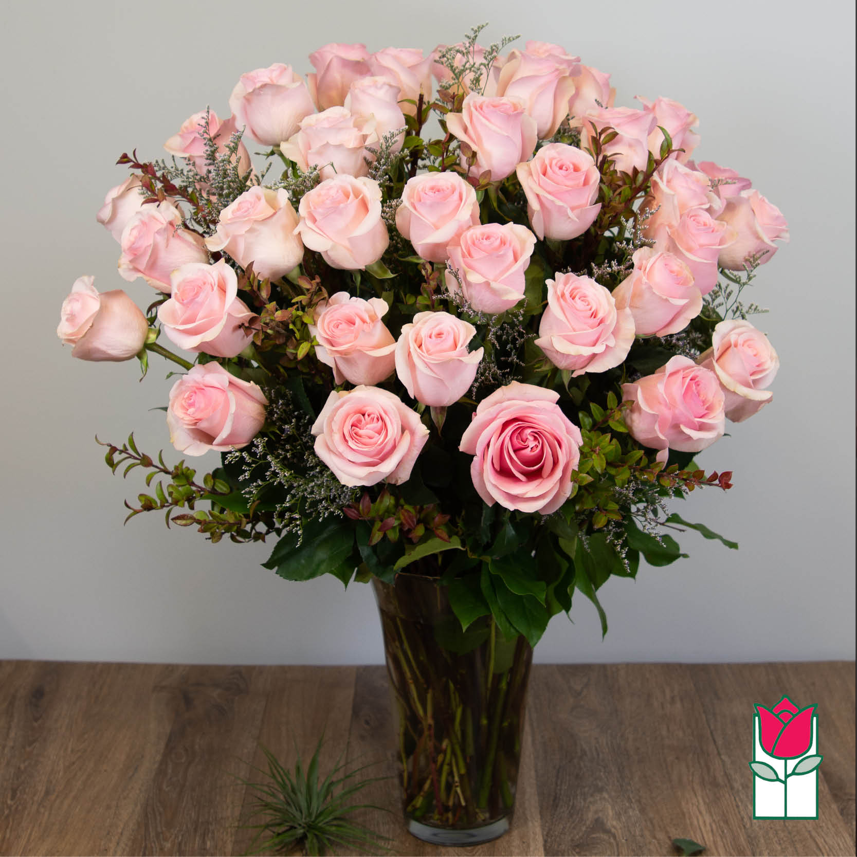 Bouquet of pale pink roses in a tall glass vase