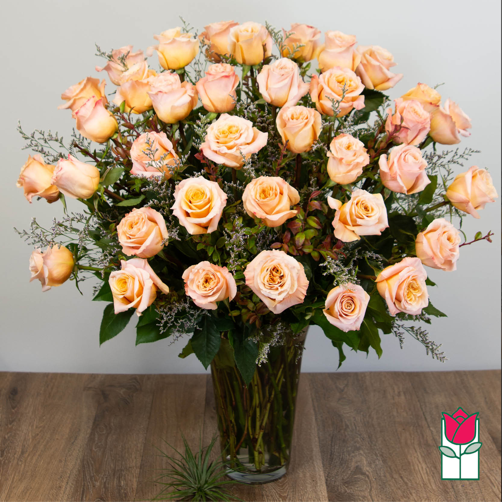 Peach roses arranged in a clear glass vase