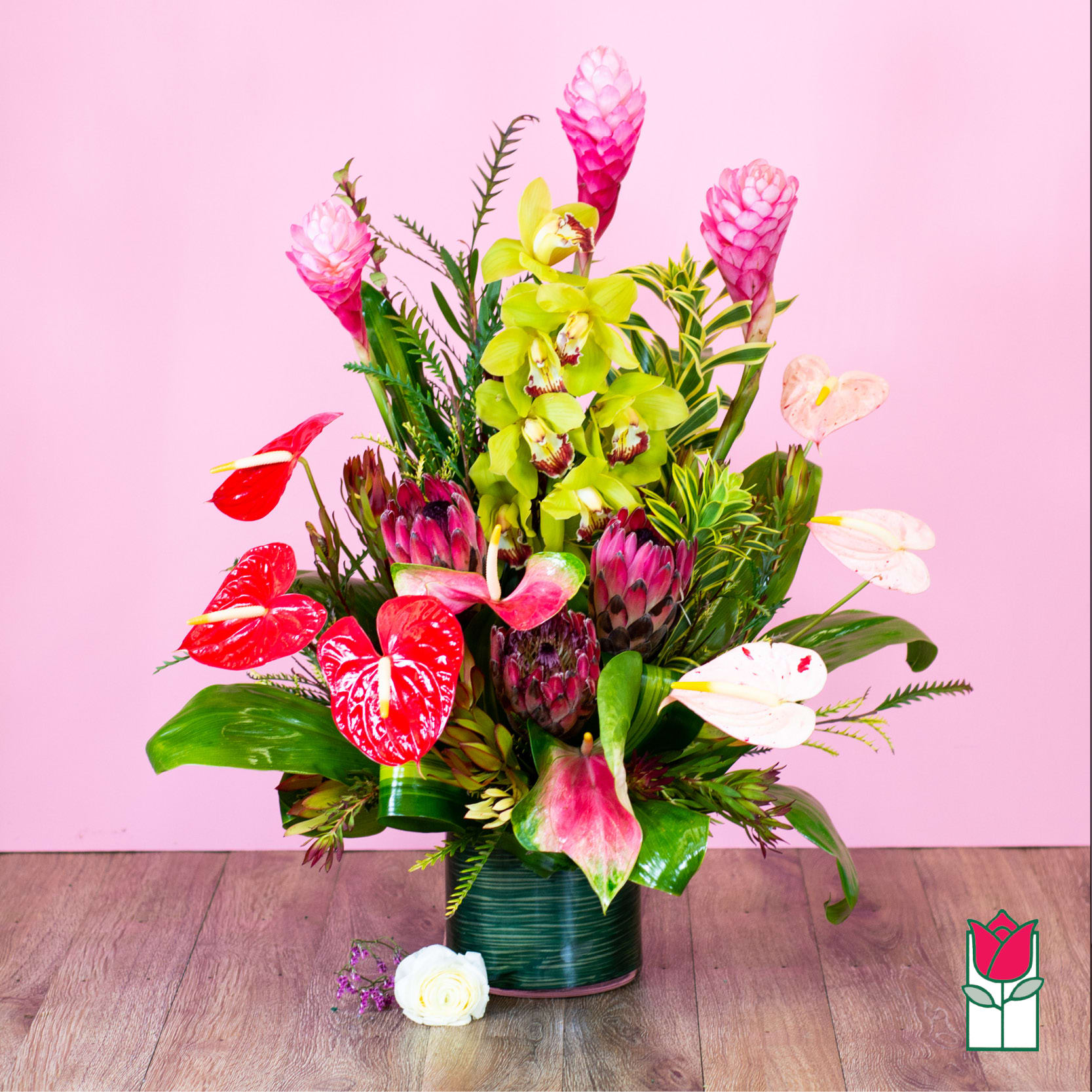 Tropical bouquet with pink ginger, orchids, and red anthuriums in a vase