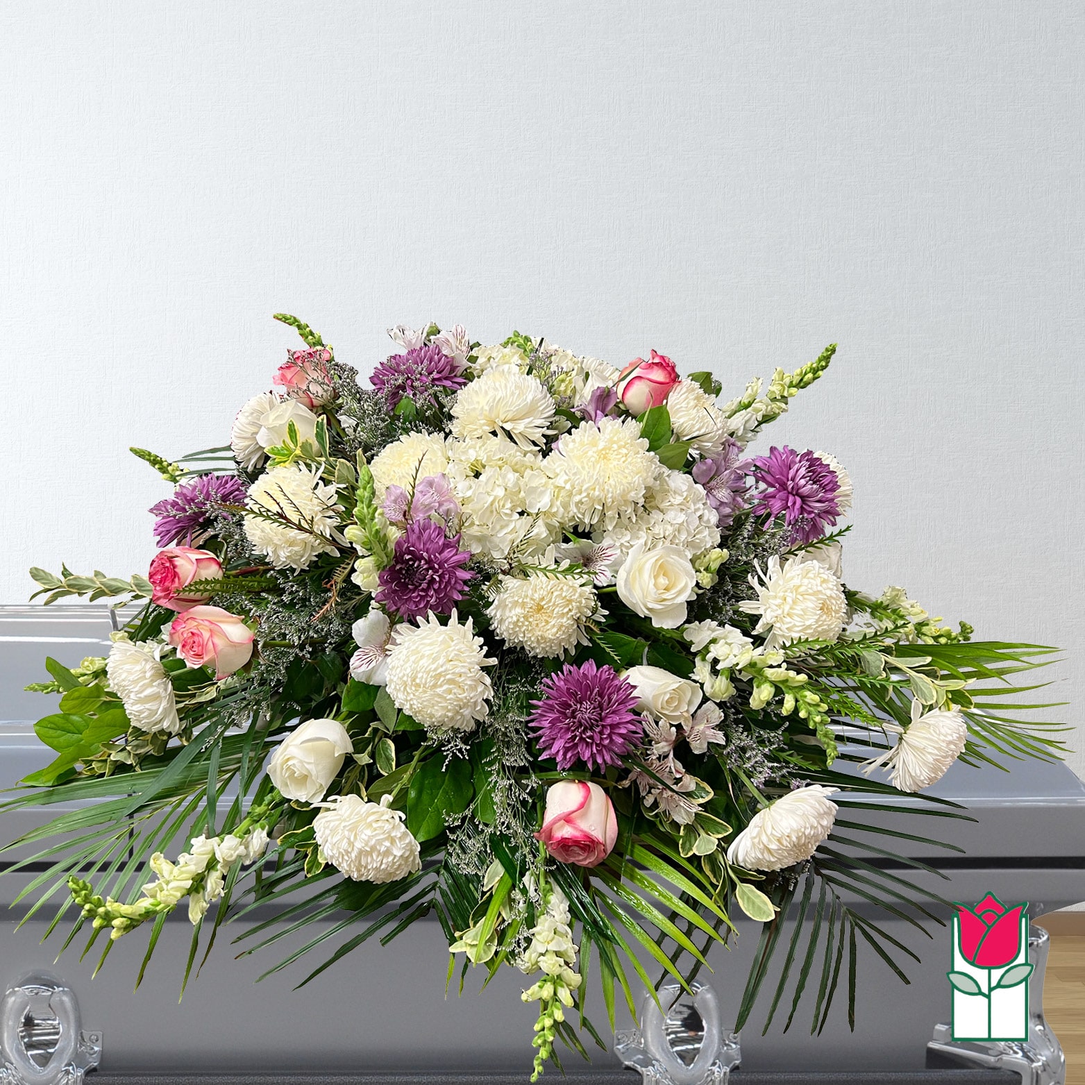 Large funeral spray with white and purple flowers and pink roses