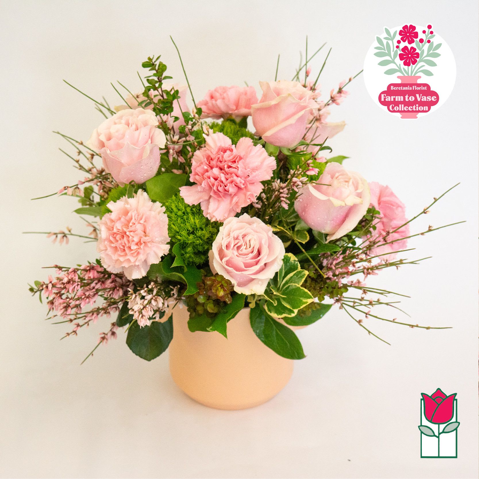 Pink roses and carnations arranged in a pale vase