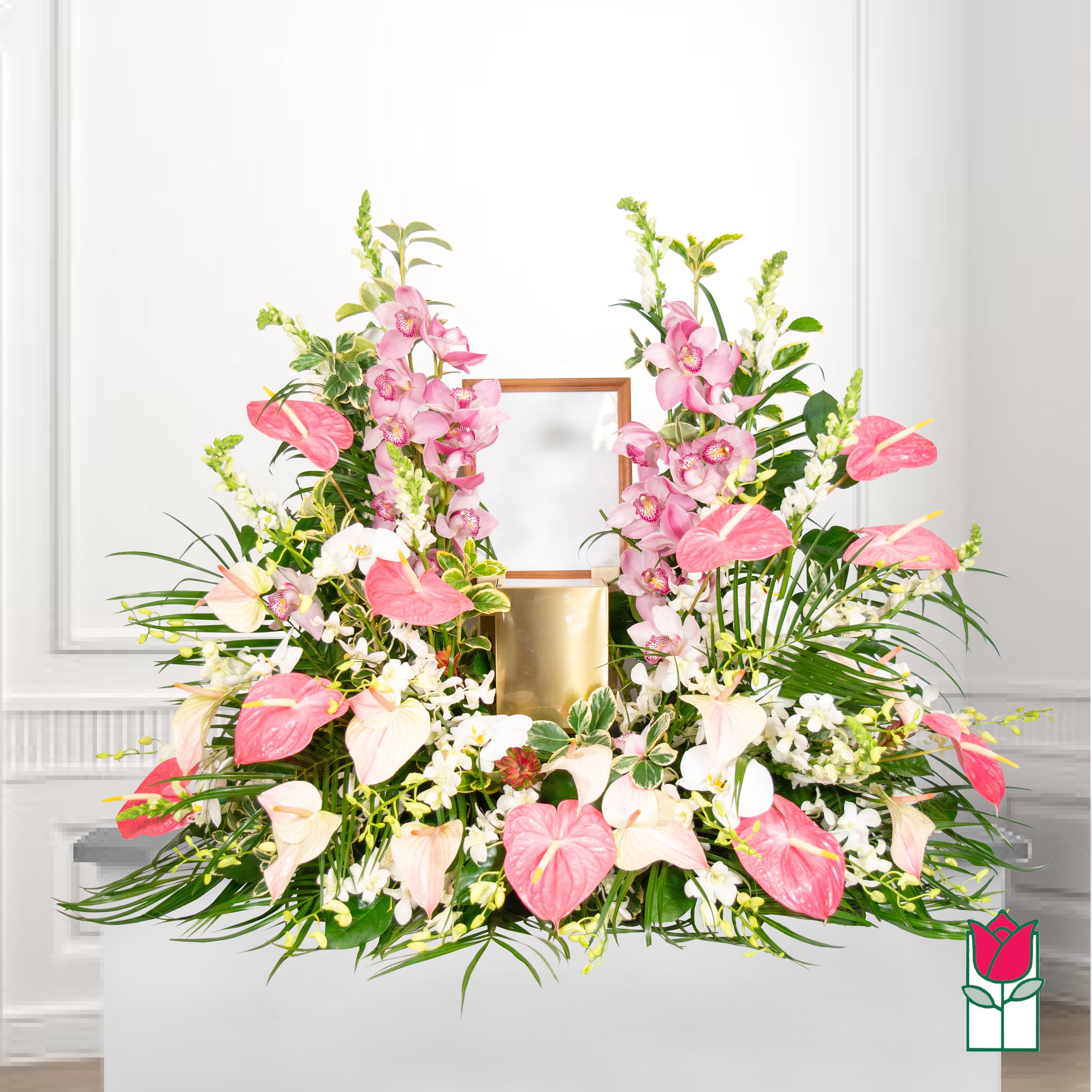 Pink and white floral arrangement with orchids and anthuriums in a gold container