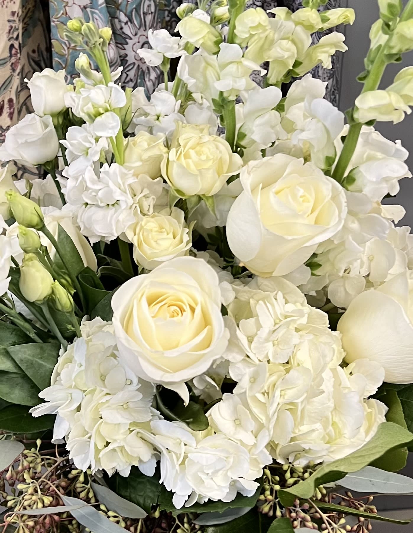 White roses and hydrangeas with pale green stock in a bouquet