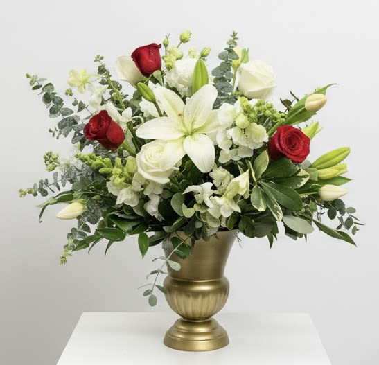 White lilies and red roses in a gold vase