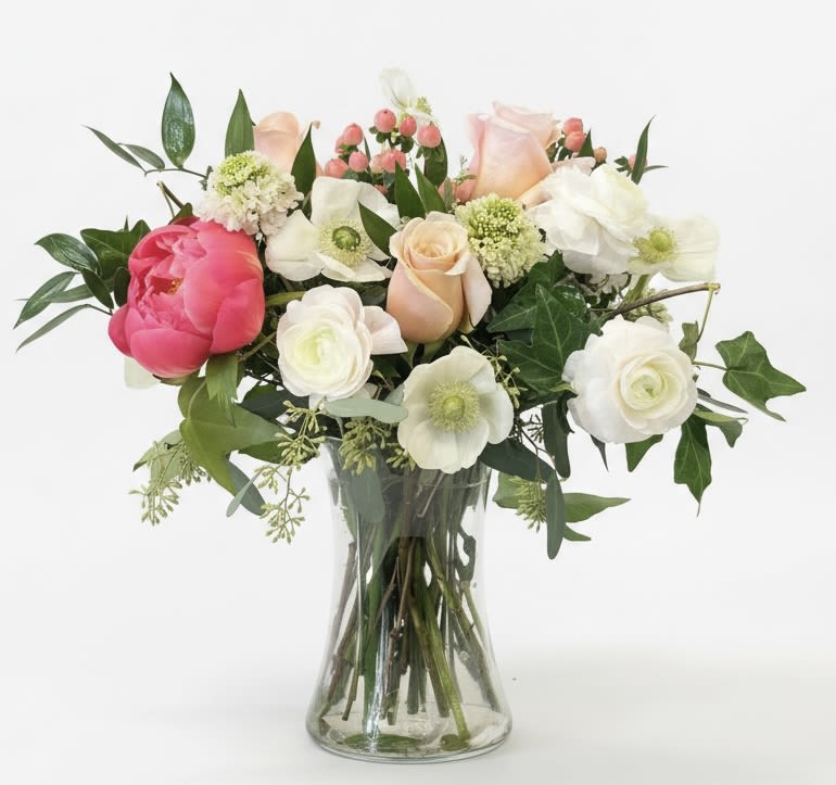 Mixed bouquet of pink and white flowers in a clear glass vase