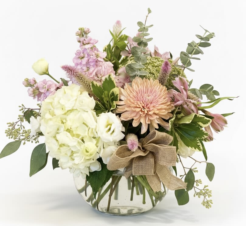 Mixed pastel bouquet in a clear glass vase with a burlap bow