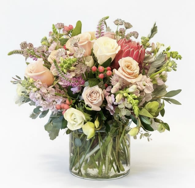 Mixed bouquet of roses and assorted flowers in a clear glass vase