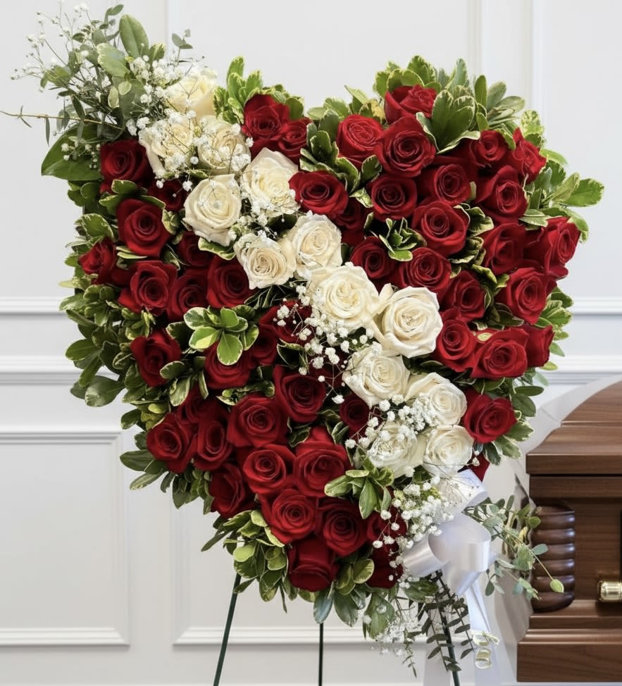 Heart-shaped arrangement of red and white roses on a stand