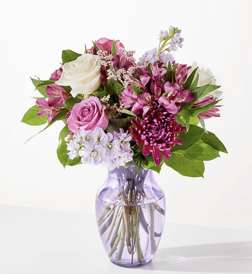 Pink and white mixed bouquet in a lavender glass vase