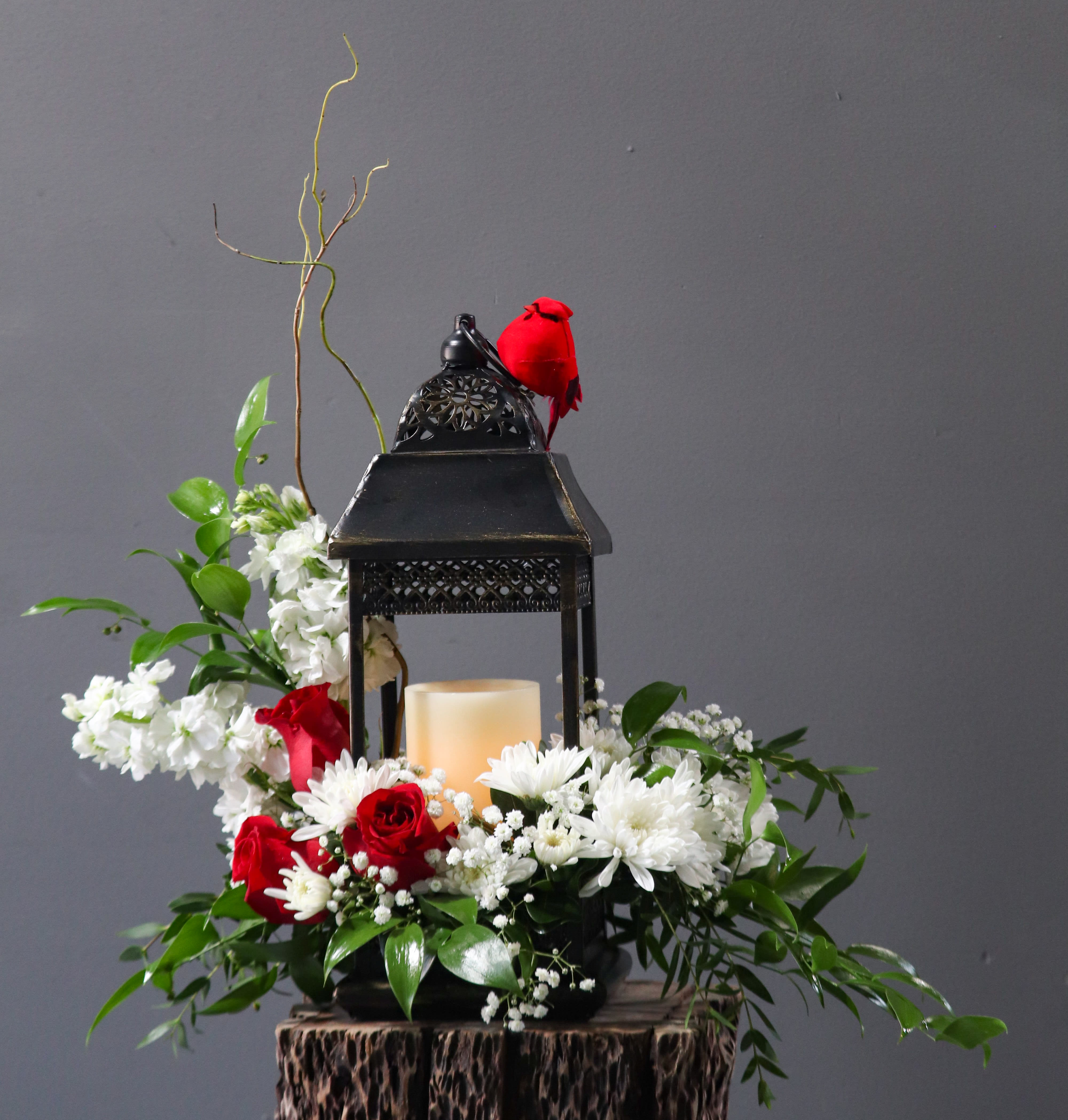 Cardinal of Light - Summer - This beautiful sympathy flower arrangement is adorned with a cardinal on a lantern. In the lantern we provide a battery lit candle.
