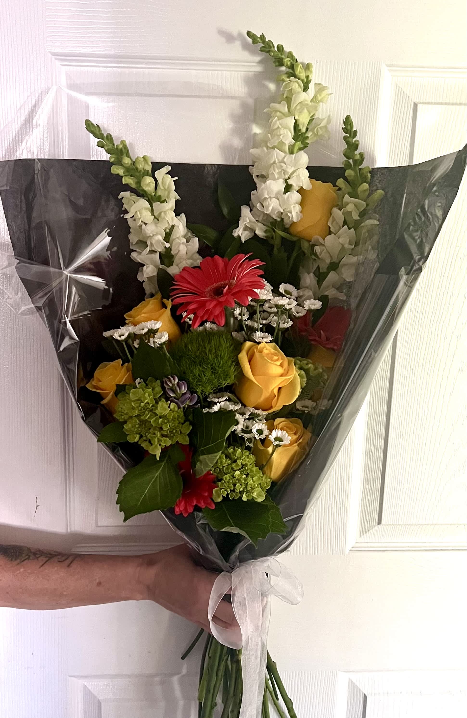 Bouquet of yellow and red flowers wrapped in black paper