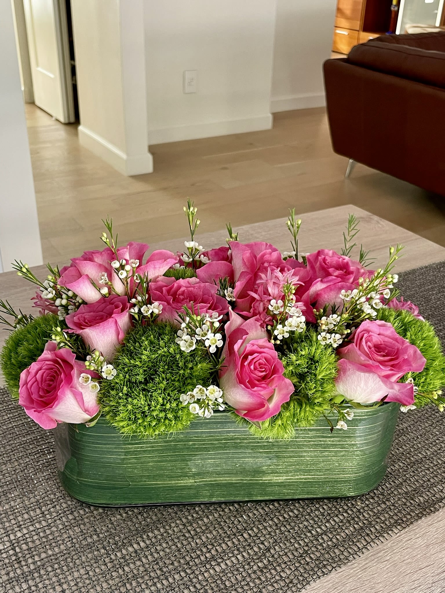 Pink roses and green moss in a rectangular green container