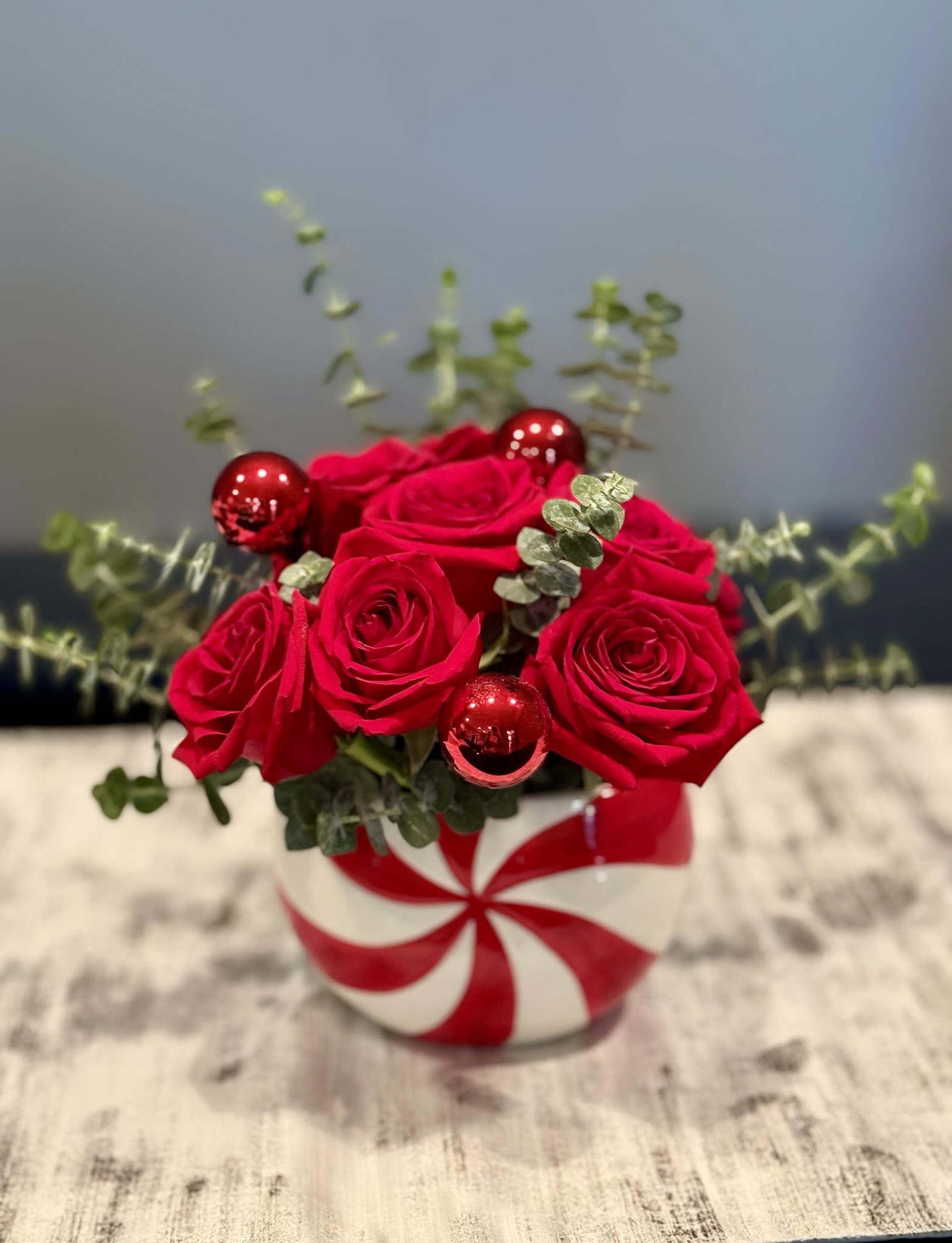 Red roses in a striped round vase with red ornaments
