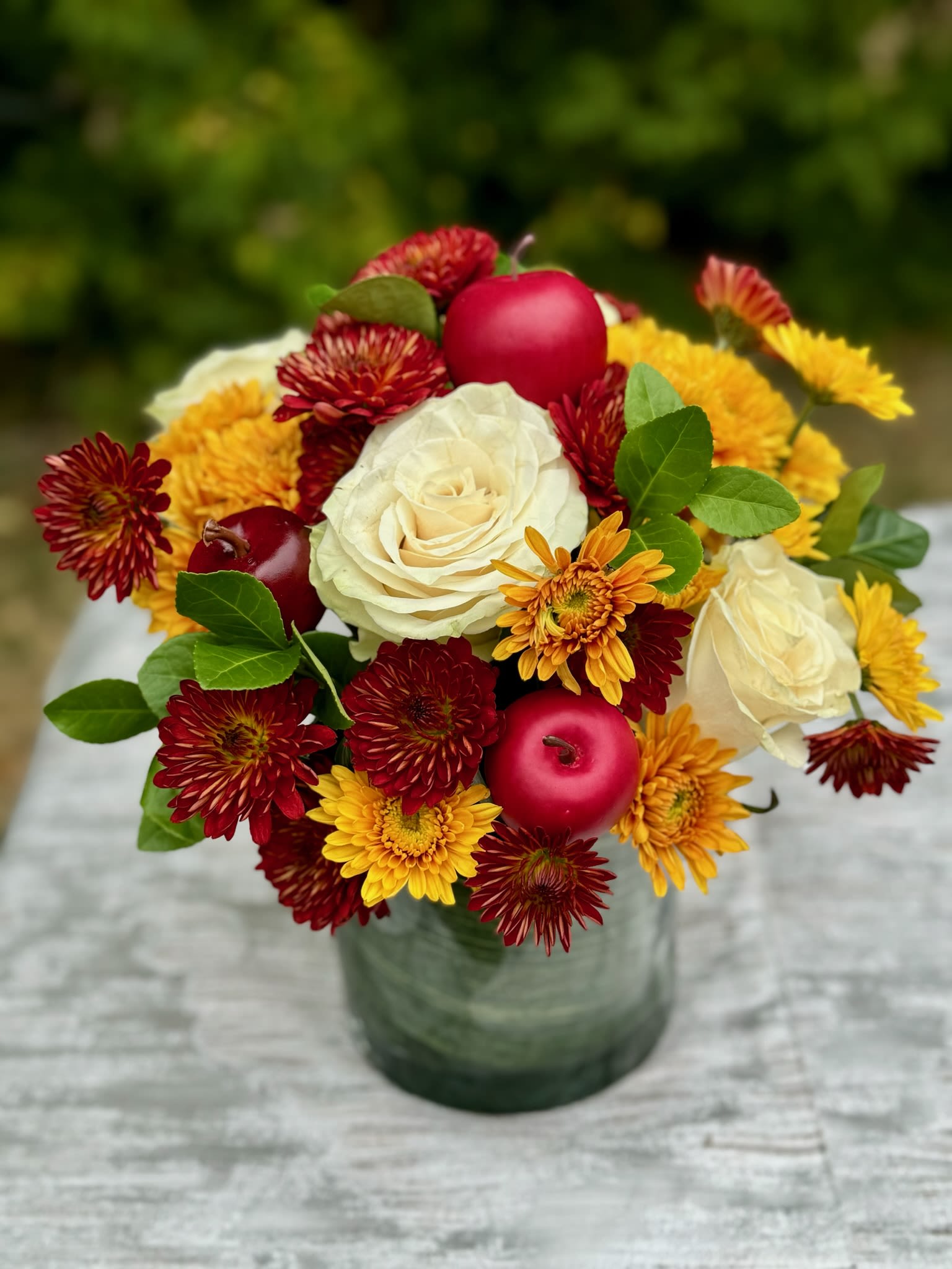 Bouquet of white roses and red-yellow chrysanthemums in a glass vase