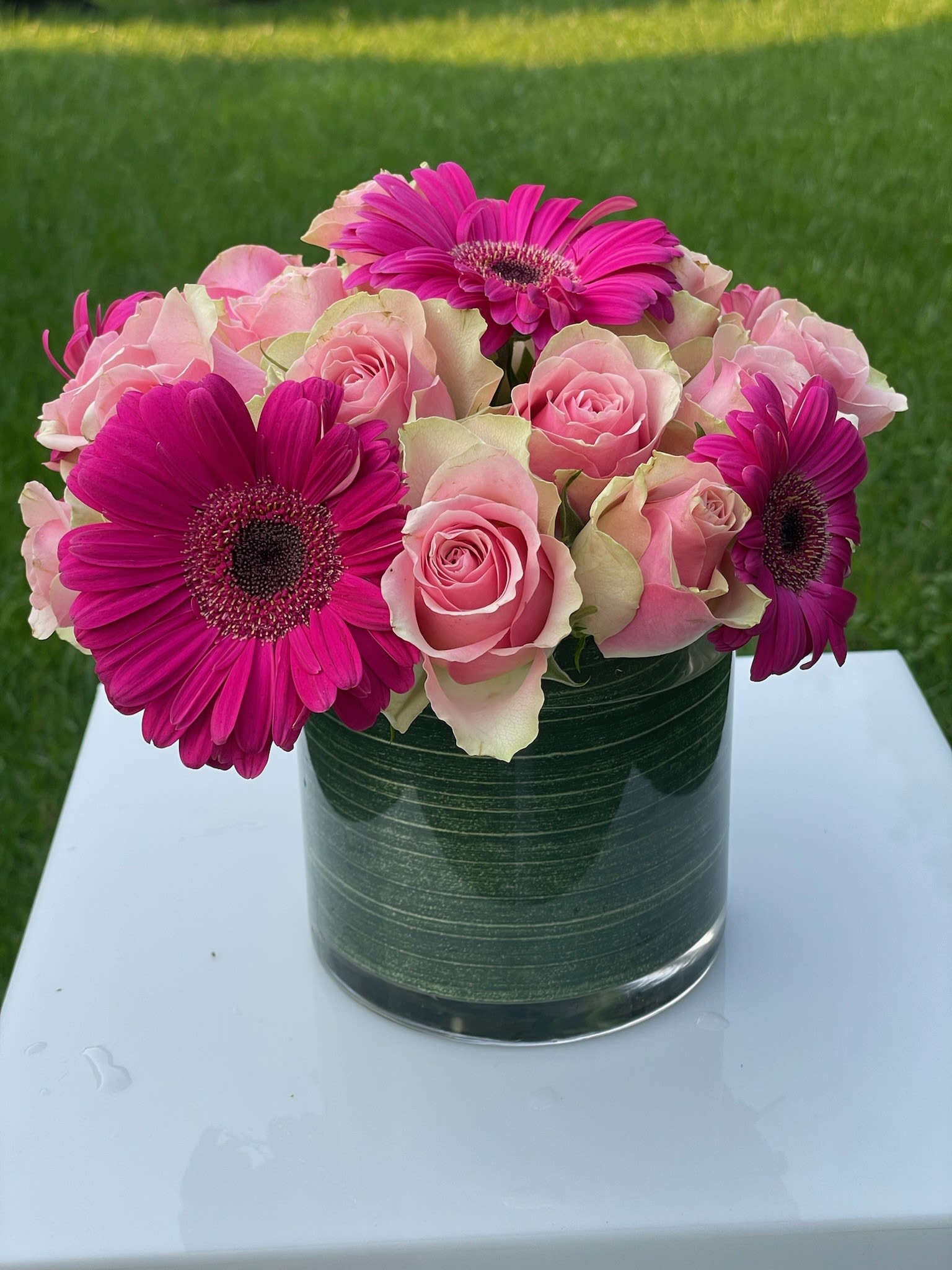 Pink roses and magenta gerbera daisies in a glass vase