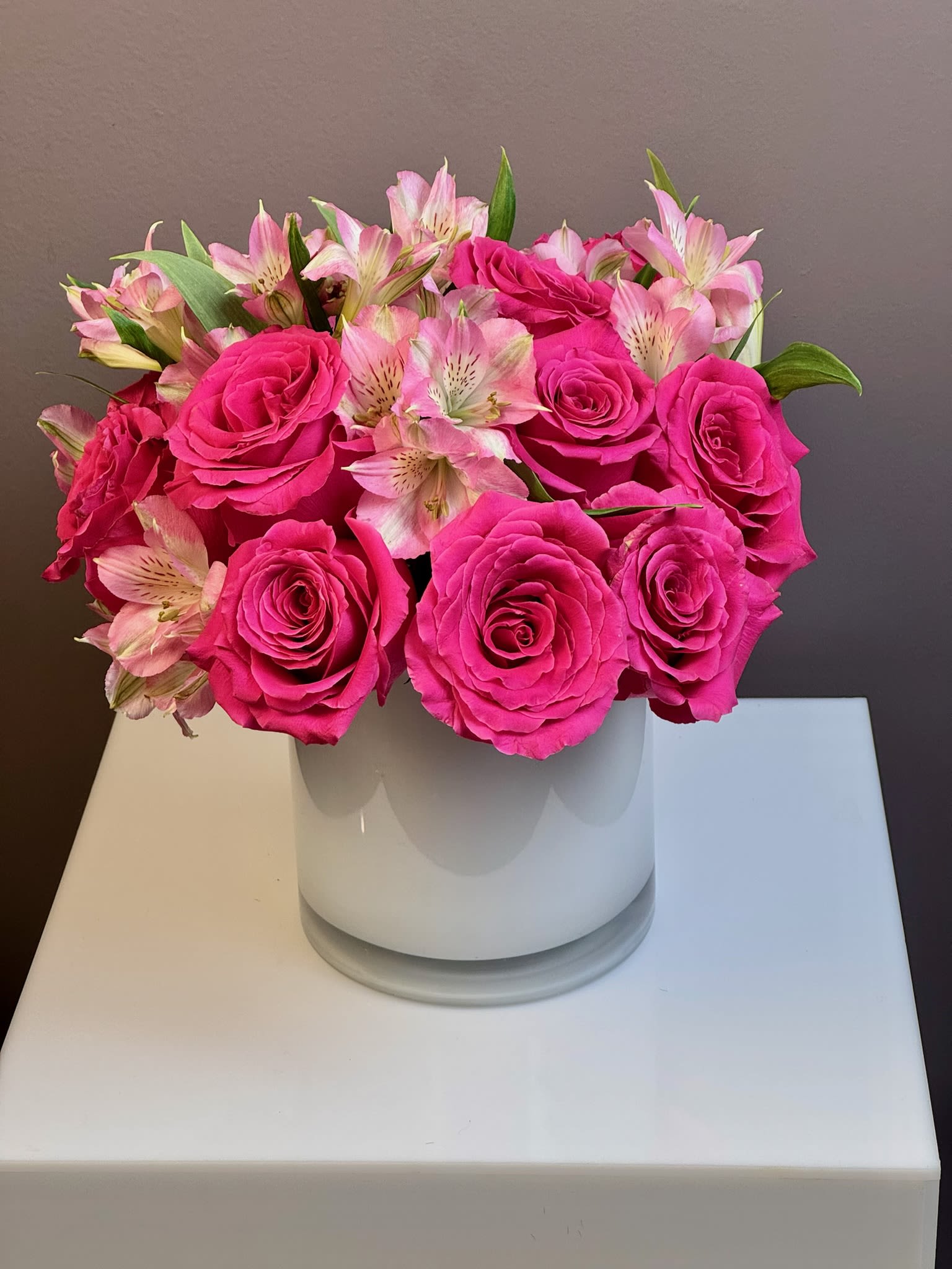 Pink roses and pale pink alstroemeria in a white vase
