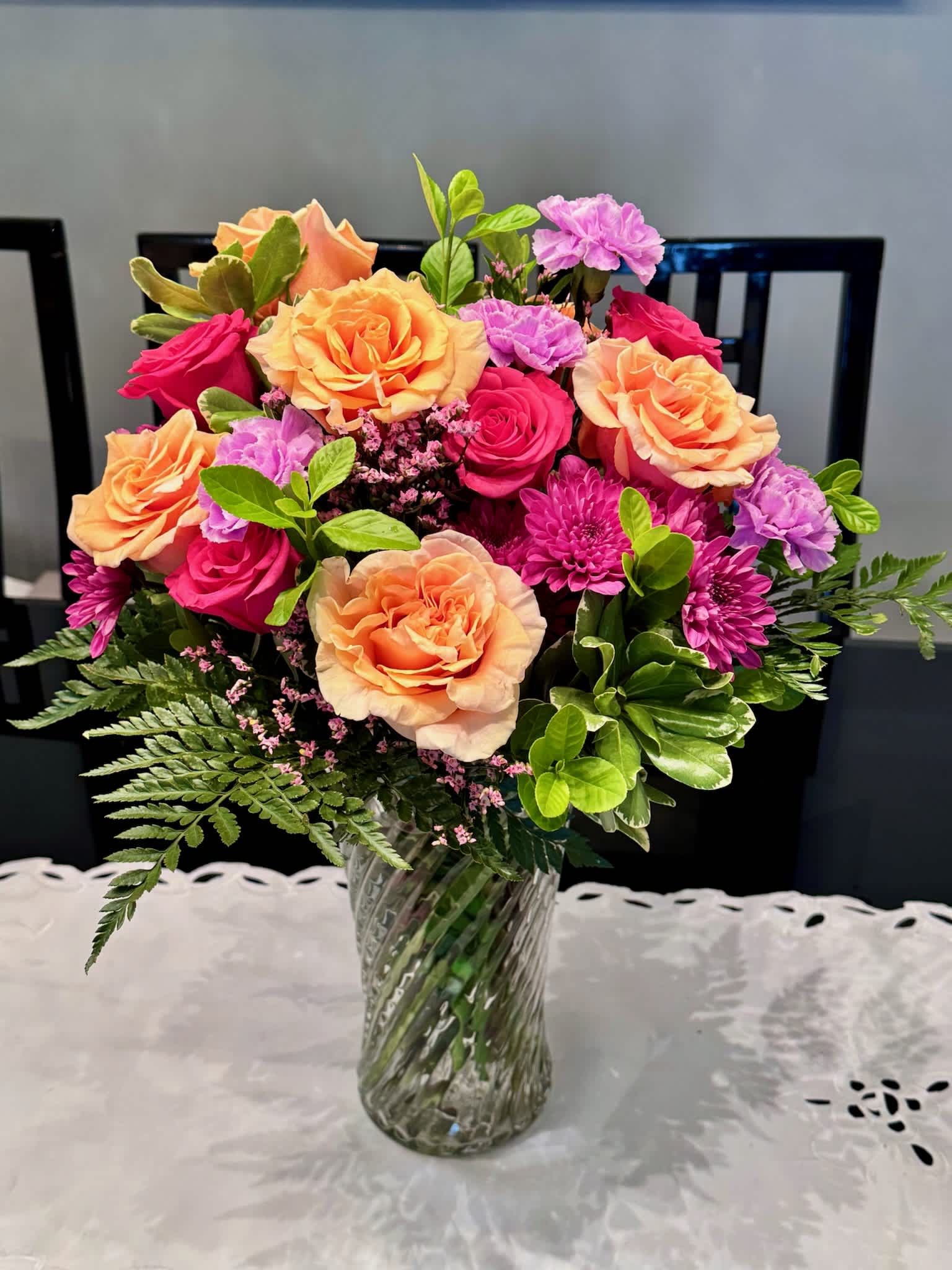 Mixed bouquet of peach and pink roses in a glass vase